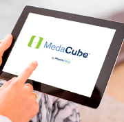 Hand holding a tablet that displays the word MedaCube. 